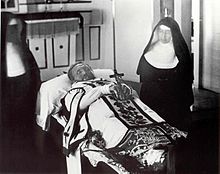 Father_Damien_on_his_funeral_bier_with_Mother_Marianne_Cope_by_his_side